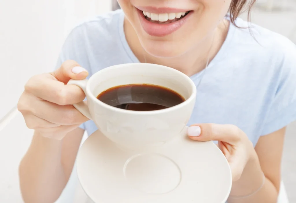 Femme buvant un café, boisson pouvant tacher les dents