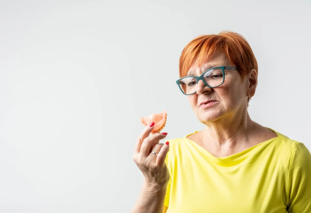 Patiente senior tenant une prothèse partielle amovible