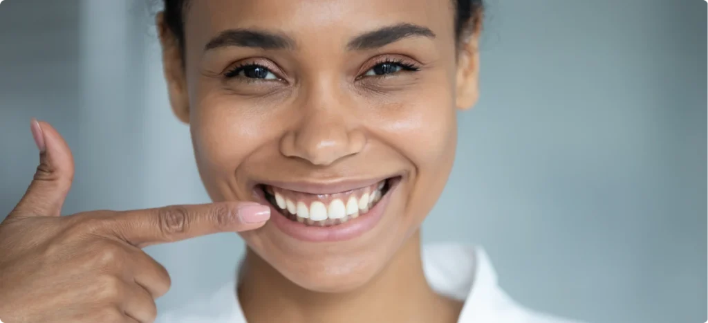 Femme souriante montrant des dents et gencives saines